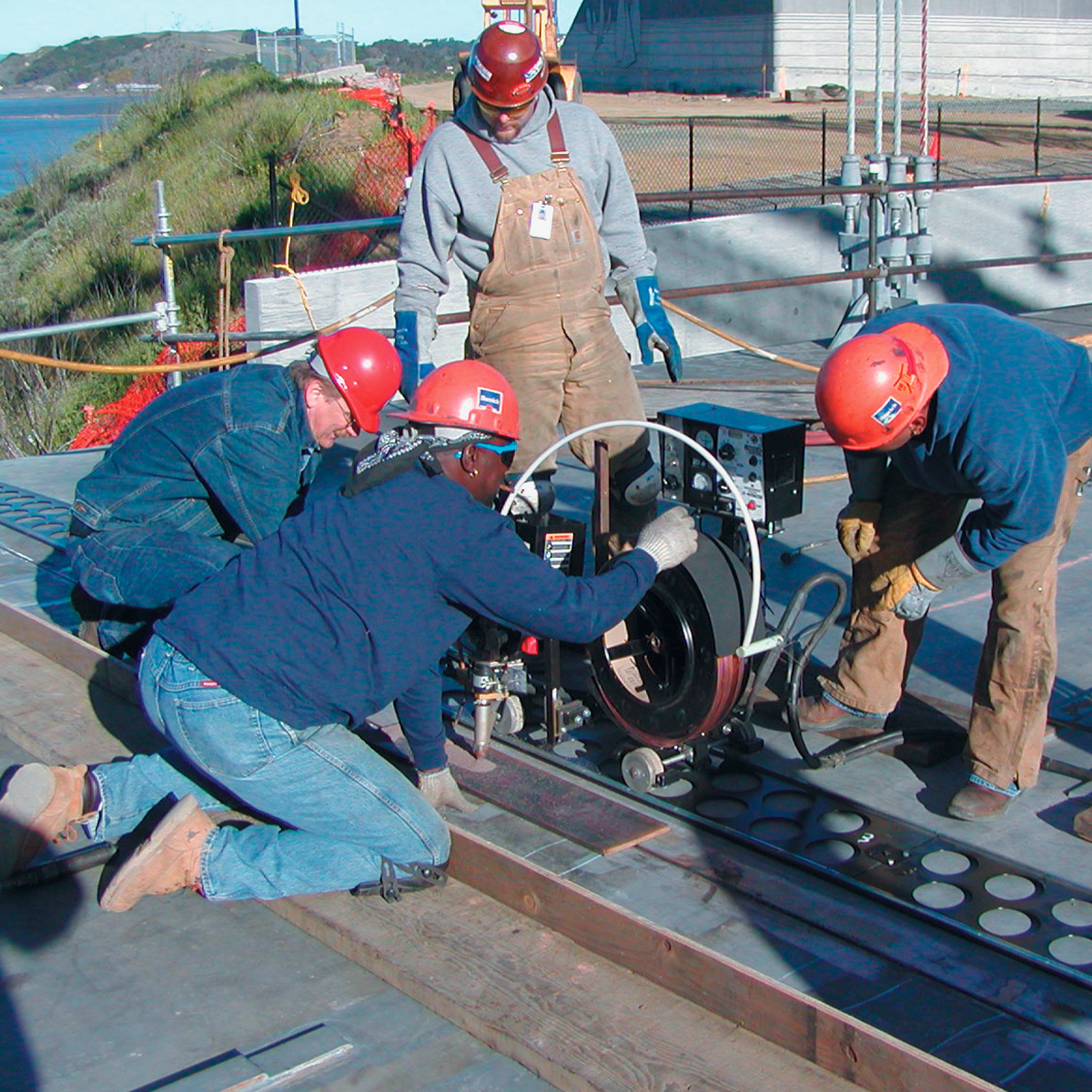 A group of workers using the LT7 Tractor Subarc-Automatic Wire feeder outside on the job.