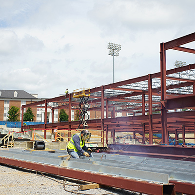 Steel erection worker welding industrial steel beam on construction site