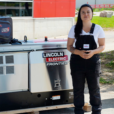 Associate standing next to Lincoln Frontier welder