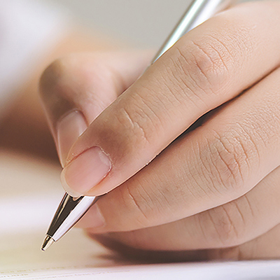 Closeup of person's hand signing a document or agreement