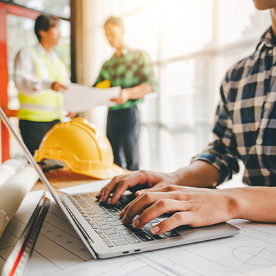 Construction worker on laptop on jobsite