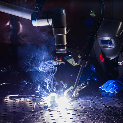 Operator observing BotX cobot welding system performing a weld