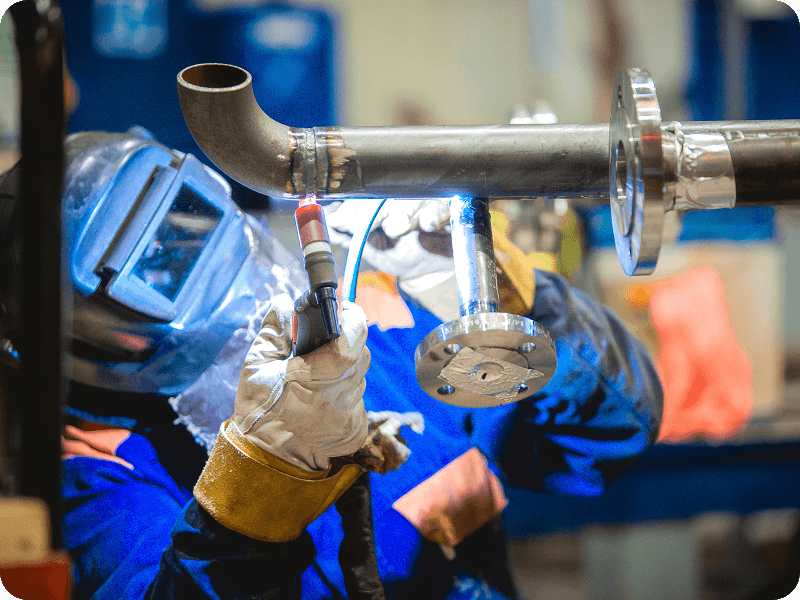 a person welding a pipe
