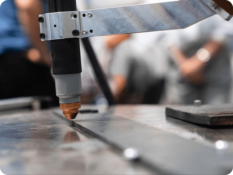 a welding cobot above a sheet of metal