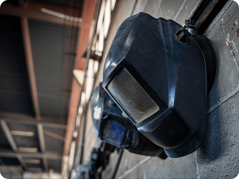 welding masks hanging from hooks