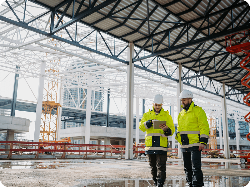 2 people in reflective coats in a warehouse