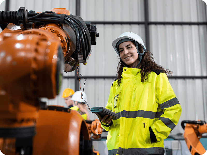 a woman in a reflective jacket inspecting welding equipment