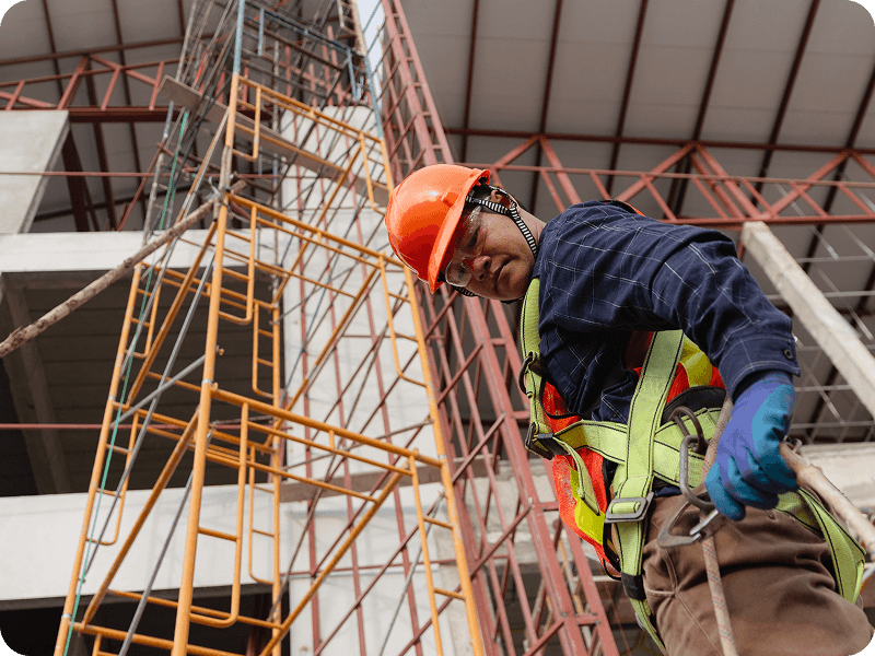 a man on a construction site climbing scaffolding