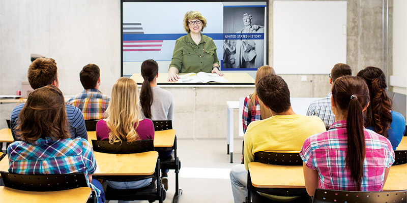 a classroom of students watching a video lesson