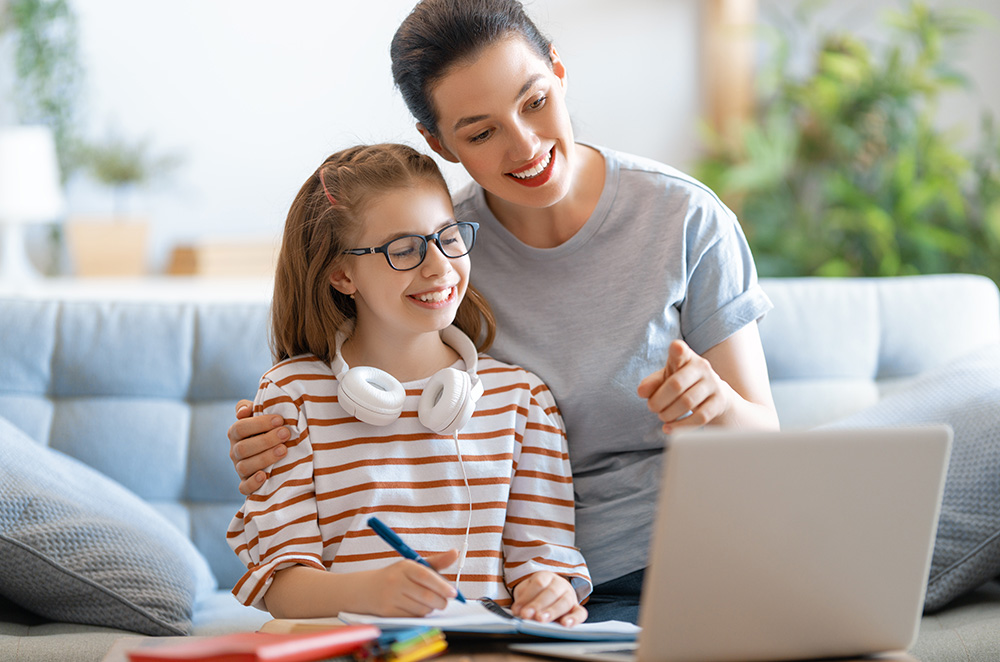 a mom and daughter doing schoolwork with a computer
