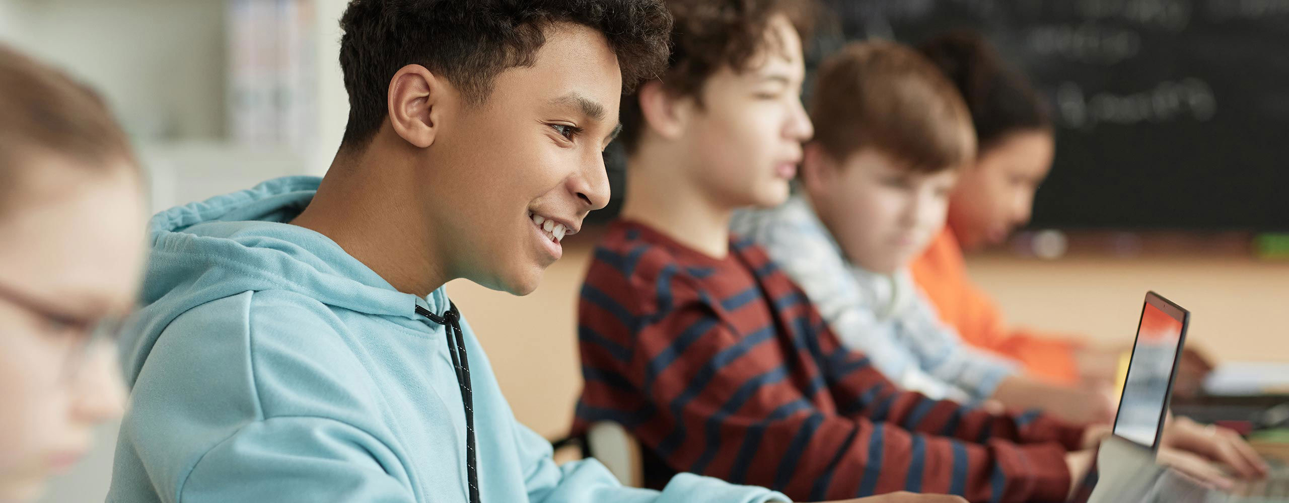 a row of students with computers in a classroom