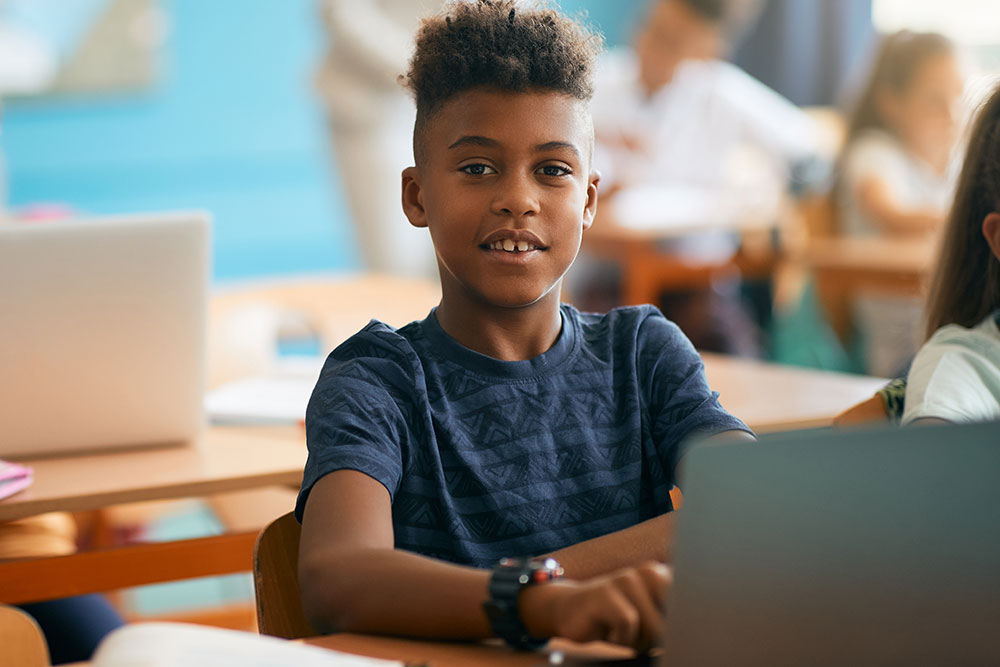 a student with a computer in a classroom