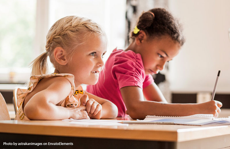 two girls working together at a desk
