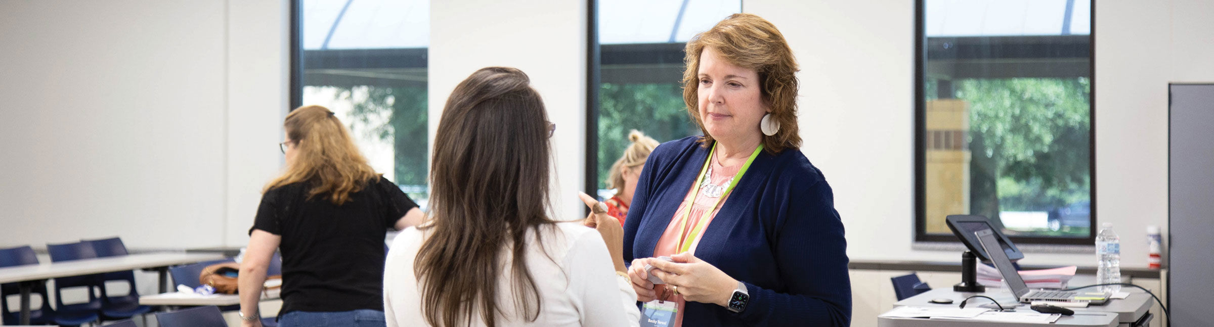 a speaker talking with attendees at a conference